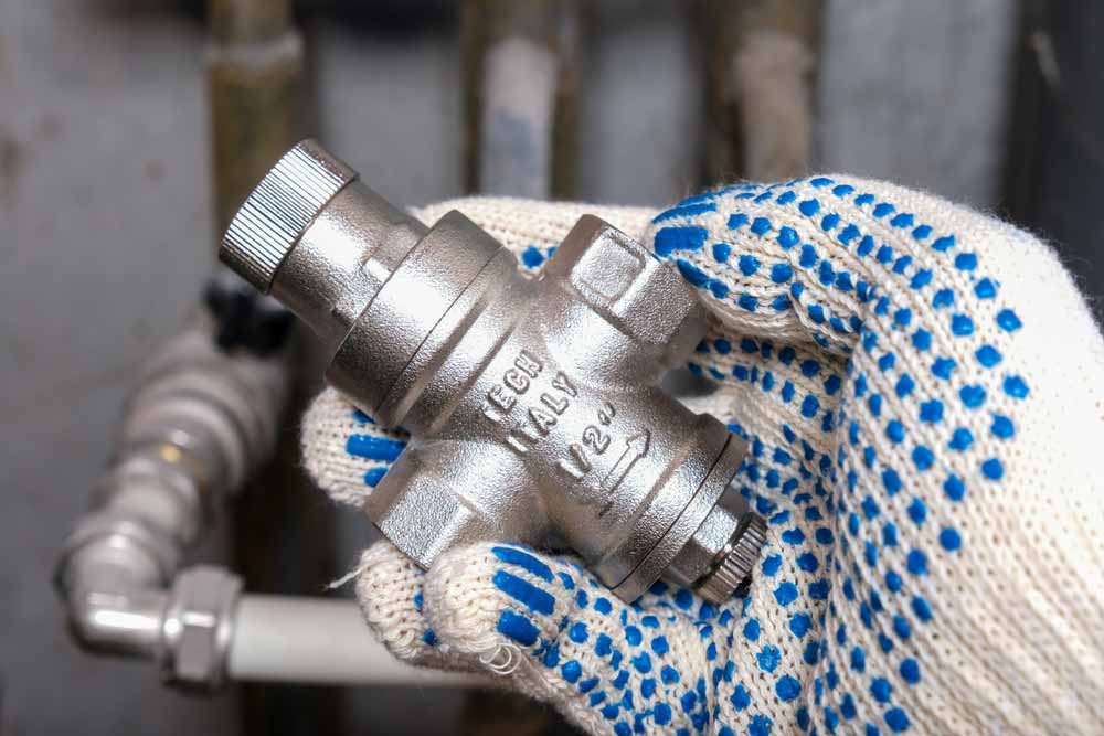 Accurate Backflow technician installing a pressure regulator