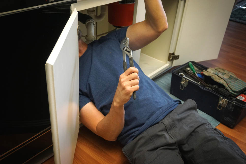 homeowner holding a plumbing wrench